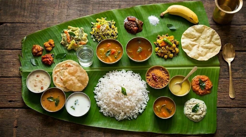 Vegetarian meal with rice, curries and accompaniments on a banana leaf